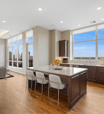 a large kitchen with a large island with white chairs at Expo, Minneapolis, MN 55414